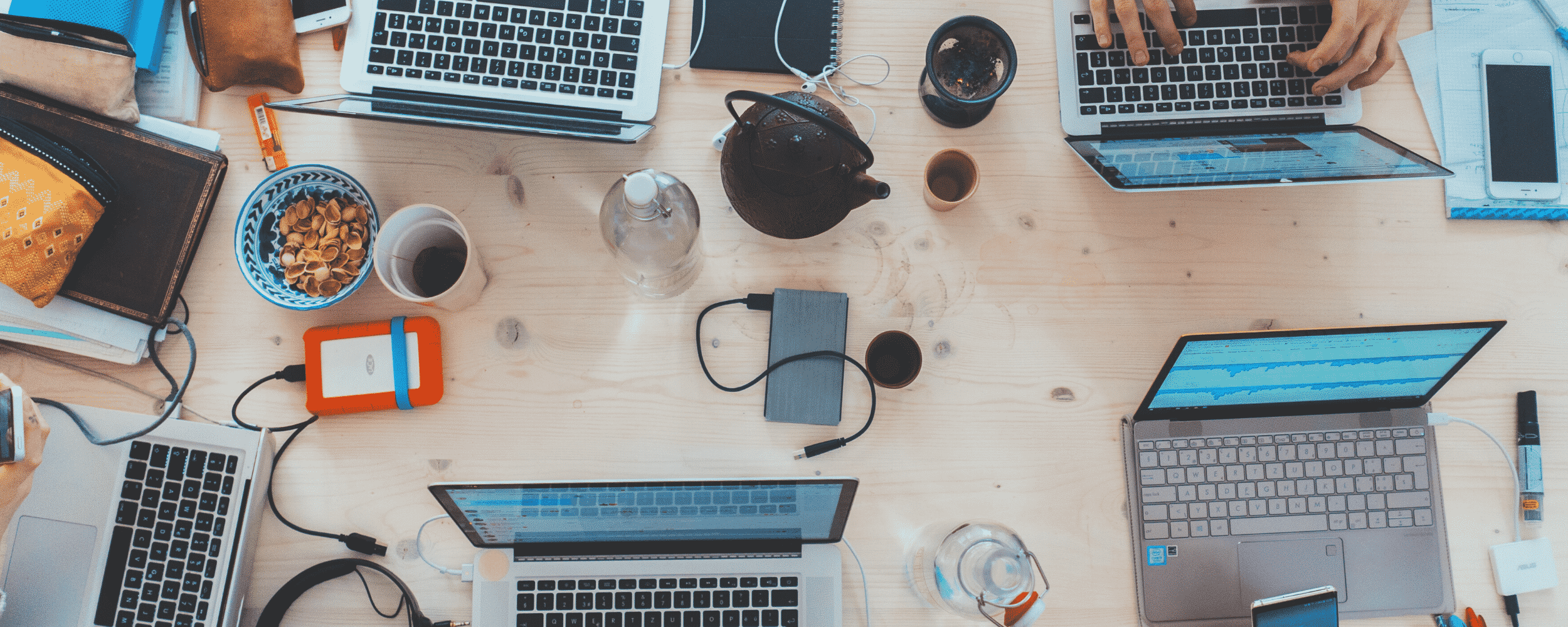 People around a meeting table with their laptops.