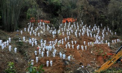 This photo taken on March 27, 2022 shows rescuers standing in a silent tribute for victims at the site of the China Eastern Airlines plane crash in Tengxian county, Wuzhou city, in China's southern Guangxi region
