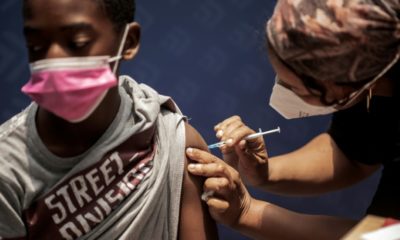 A boy receives a dose of the Pfizer/BioNTech vaccine against COVID-19 at Discovery vaccination site in Sandton, Johannesburg