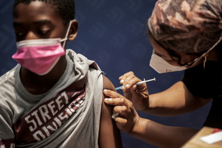 A boy receives a dose of the Pfizer/BioNTech vaccine against COVID-19 at Discovery vaccination site in Sandton, Johannesburg