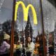 People look out of the window of a McDonald's restaurant as the towers of the Kremlin reflect in it in Moscow on January 30, 2020