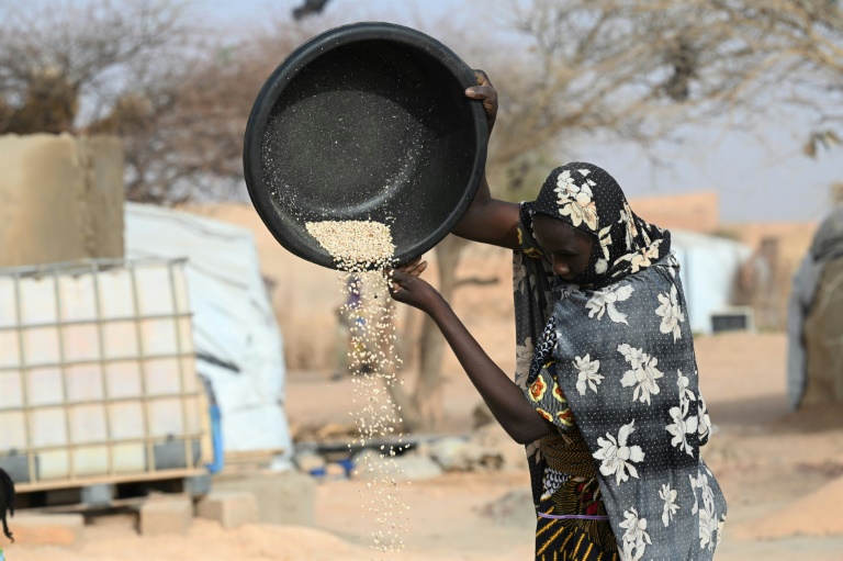 Every grain counts: A woman at a displaced persons' camp in Ouallam, Niger, pours food from a container