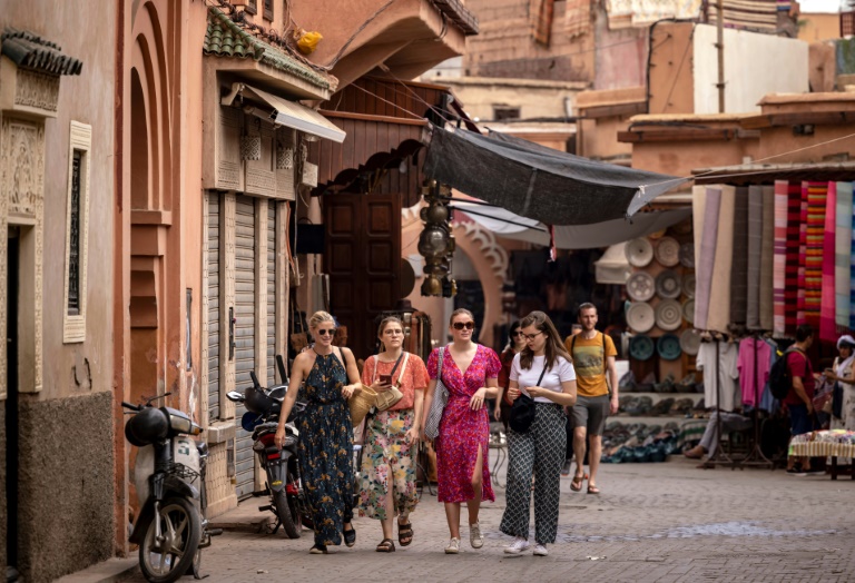 Tourists walk in the old city of Marrakesh, the city at the foot of the High Atlas mountain range