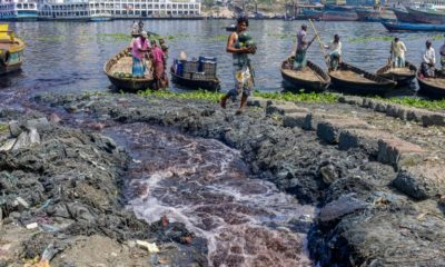 Industrial waste enters the Buriganga River as boatmen wait for passengers in Karanigonj