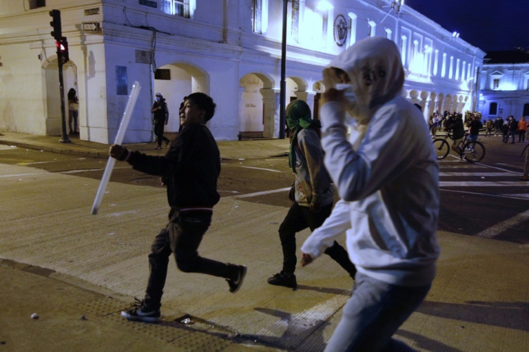 A demonstrator runs with a neon tube to throw at the police during Indigenous-led protests against the government in Ecuador