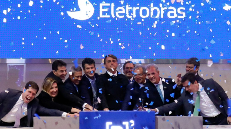 Brazil's President Jair Bolsonaro (C) ringing the bell at the Brazilian B3 Stock Exchange, in Sao Paulo, Brazil, on June 14 2022 to open trading on the newly privatized Electrobras company Brazilian President Jair Bolsonaro on Tuesday sealed the privatisation process of Eletrobras, Latin America's largest electricity company, with a symbolic bell ringing on the Sao Paulo stock exchange, where new shares were offered, reducing the state's shareholding.