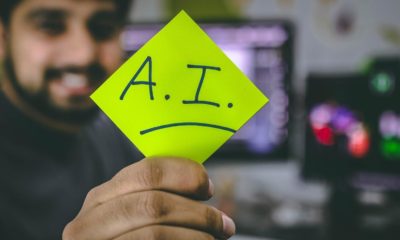 Person holding green paper photo with the letters A.I.