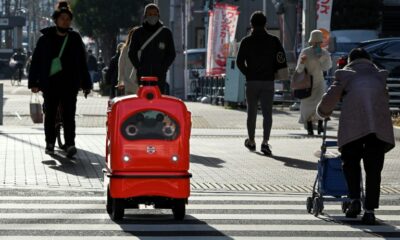A four-wheeled robot dodges pedestrians on a street outside Tokyo, part of an experiment businesses hope will tackle labour shortages and rural isolation