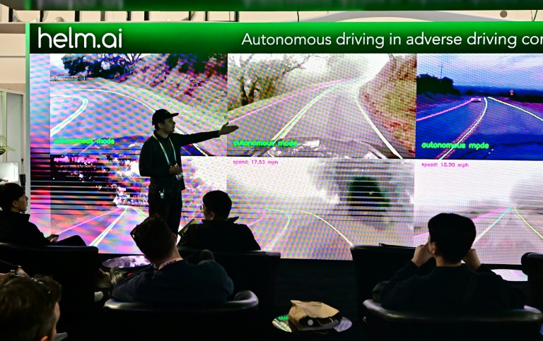 People sample an autonomous driving experience from Helm.ai during a display at the Consumer Electronics Show