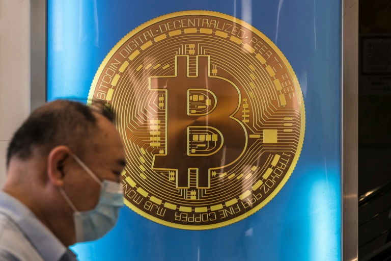 A man walks past a bitcoin poster in Hong Kong on April 15, 2024